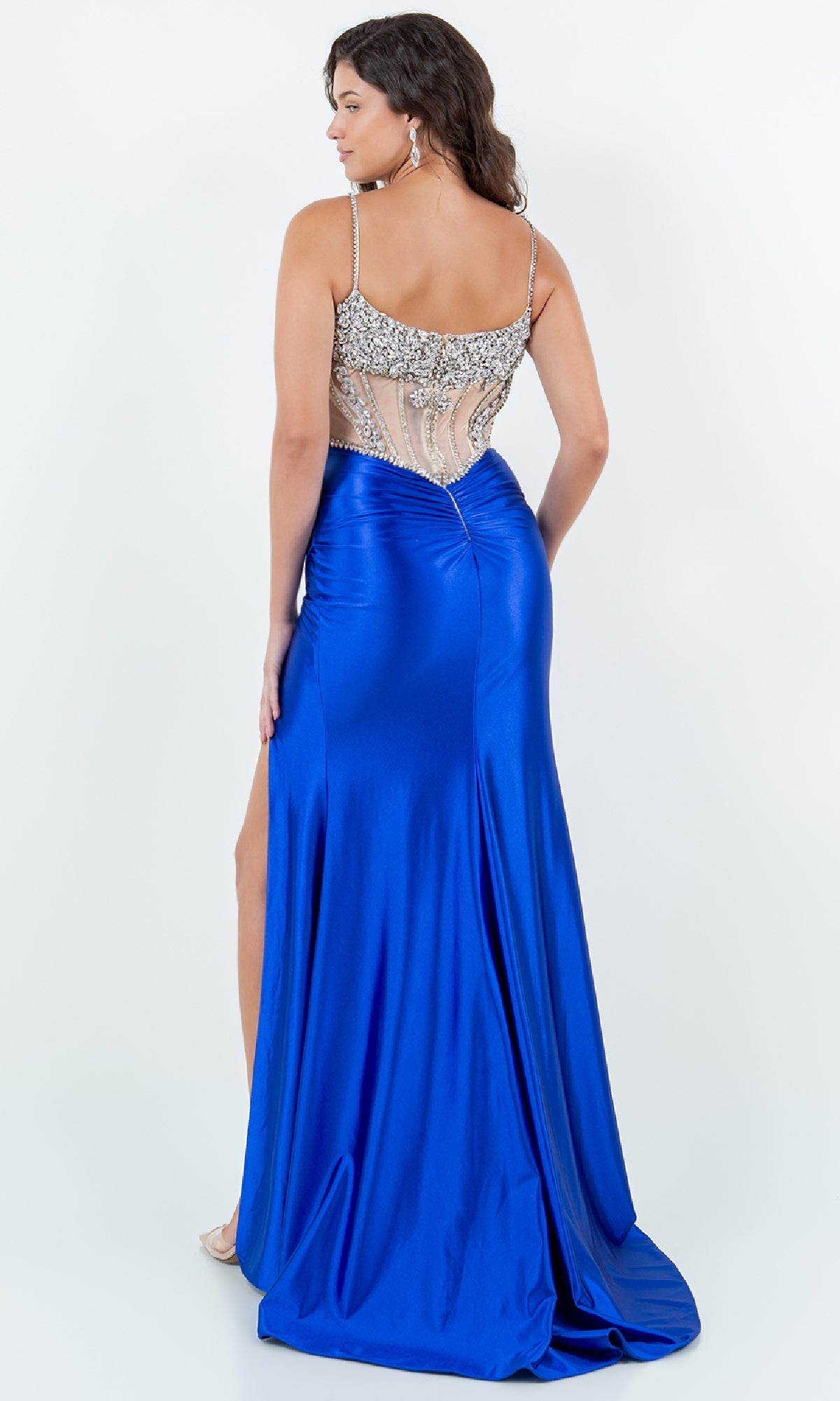 A woman faces away in the Cinderella Couture 8171J beaded-bodice prom gown—a royal blue formal dress with a sheer embellished back and high slit, perfect for special occasions.